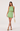 Woman wearing a green dress with lace details on a white background