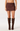 A model wearing a dark brown faux-suede mini skirt and matching dark brown over-the-knee boots, shown from the waist down on a light gray studio background.