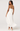 Woman wearing a white pleated dress on a white background