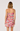 Woman wearing a floral dress on a plain background