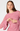 A woman wearing a pink lace long-sleeve dress with a round neckline and flared bell sleeves, posed against a light gray studio background.