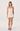 Woman wearing a strapless beige dress on a white background