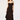 A woman modeling a long black ruffled spaghetti-strap dress against a plain light gray studio background.