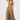 A woman modeling a sleeveless leopard-print halter midi dress with a flared skirt, paired with black strappy sandals, against a plain light gray studio background.