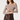 A woman modeling an off-the-shoulder long-sleeve top with a brown and beige geometric pattern, paired with a dark brown faux-leather wrap skirt, against a plain light background.