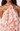Floral halter dress with ruffled layers on a white background