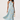 Woman wearing a light blue floral dress on a white background
