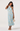 Woman wearing a light blue floral dress on a white background