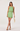 Woman wearing a green dress with lace details on a white background