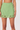 Green mini skirt with scalloped hem on a plain background