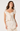 A woman modeling a cream-colored two-piece set featuring a ruffled sweetheart top with a tie-front detail and a matching textured skirt, set against a plain light background.