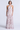 Woman wearing a long, tiered dress with a floral pattern on a white background
