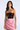 A woman modeling a strapless cocktail dress with a dark burgundy sequined bodice and a light pink satin skirt, set against a plain light gray studio background.