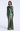 A woman modeling a floor-length metallic green gown with long sleeves, a round neckline, a draped wrap-style skirt detail, and a high front slit, photographed against a clean light gray studio background.