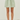 Green and white striped skirt worn by a person on a white background