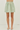 Green and white striped skirt worn by a person on a white background