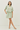 Woman wearing a light green and white striped outfit on a white background