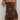 A woman wearing a brown strapless romper with white polka dots, paired with matching brown shorts, set against a plain light background.