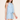 Woman wearing a light blue sleeveless dress with a subtle pattern on a plain background