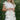 Woman wearing a floral dress with ruffled layers outdoors.