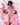 Woman wearing a pink dress with puff sleeves against a colorful abstract background