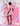 Woman in a pink dress standing against a colorful abstract background