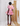 Woman wearing a colorful dress standing in front of a textured wall.