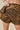 Person wearing tiger-striped shorts on a beige background
