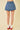 Denim skirt worn by a person on a beige background