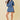 Woman wearing a denim outfit with red sneakers on a beige background