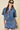 Woman wearing a denim outfit with sunglasses on a beige background