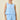 Woman wearing a light blue sleeveless top and shorts set on a beige background