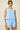 Woman wearing a light blue sleeveless top and shorts set on a beige background