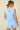 Light blue romper with lace details on a beige background