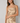 Woman wearing a satin cami in champagne. 