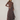 A woman modeling a brown ribbed mock-neck long-sleeve top paired with a dark brown and gray plaid patterned maxi skirt, styled with black boots against a neutral studio backdrop.