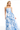 Woman wearing a strapless blue floral dress on a white background