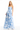 Woman wearing a strapless blue floral gown on a white background