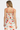 Woman wearing a floral dress with red straps on a white background