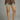 Brown polka dot shorts with lace trim worn by a person on a gray background