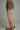 Brown polka dot skirt with lace trim worn by a person on a gray background