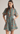 A woman modeling a short-sleeve collared mini dress with a teal background and a red, orange, and green floral pattern, featuring a self-tie waist belt.
