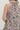 Pink and green patterned dress with a bow detail on a plain background