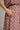 Close-up of a person wearing a dusty rose pink and white gingham dress with dark red polka dots, showing a hand in a side pocket.