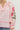 Pink and white striped blouse with floral embroidery on a plain background