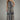 Woman wearing a patterned jumpsuit on a plain background