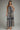 Woman wearing a patterned jumpsuit on a plain background