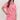 Woman wearing a pink outfit with red patterns on a white background