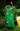 Woman wearing a green dress with floral embroidery standing outdoors.