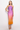Woman wearing a gradient dress with purple to orange color on a white background